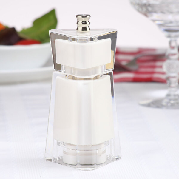 A clear Chef Specialties Kate White Acrylic salt shaker on a table.