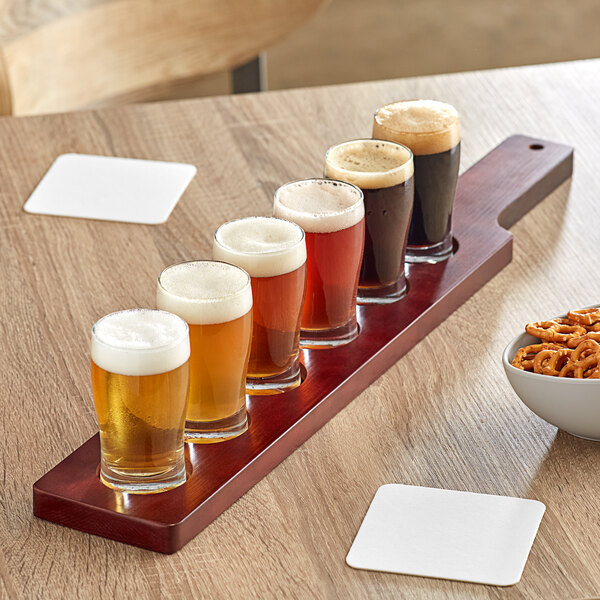 An Acopa mahogany wood board with beer glasses on it.