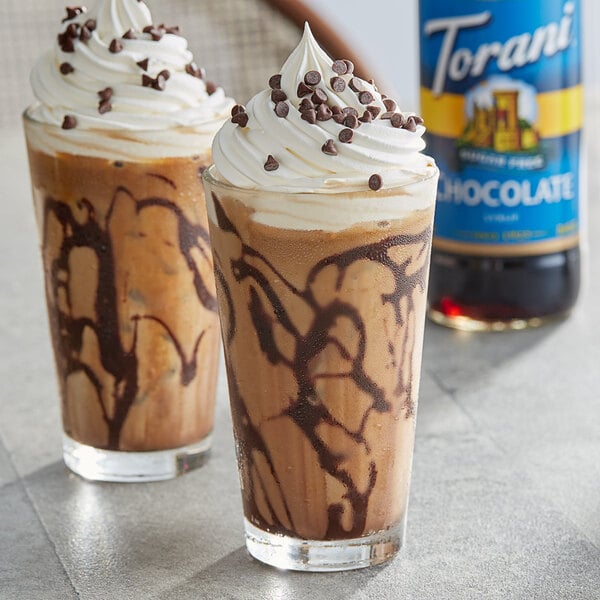 Two glasses of iced drinks with Torani Sugar-Free Chocolate Syrup and whipped cream on top.