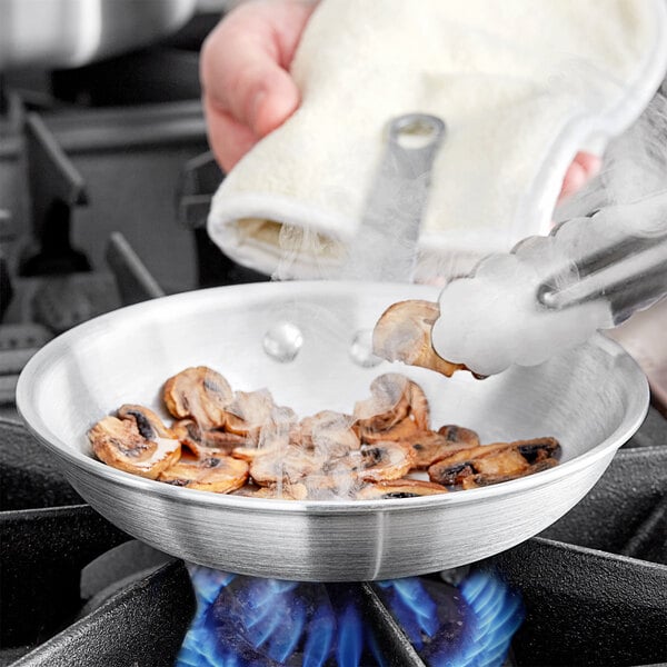 Mushrooms cooking in a Choice aluminum fry pan.