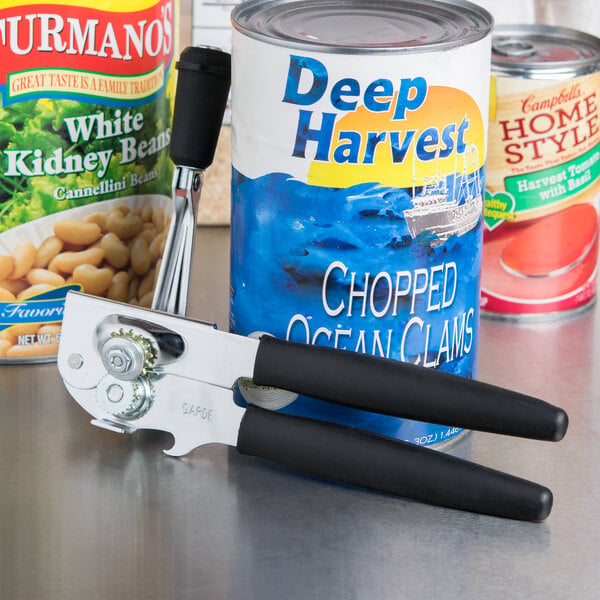 A Garde handheld can opener with black handles opening a can of beans.