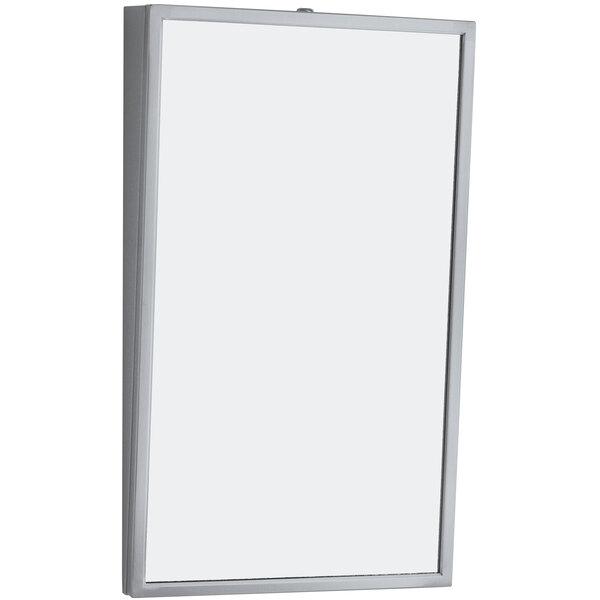 A white rectangular Bobrick tilt mirror on a wall.