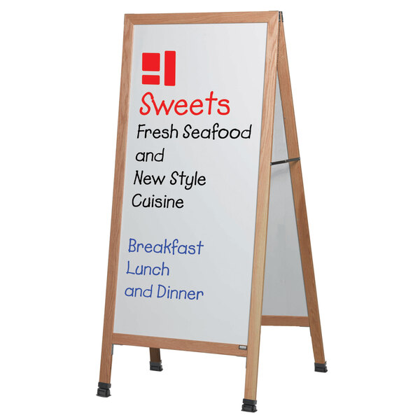 An oak A-Frame sign board with white write-on porcelain marker board displaying black text.