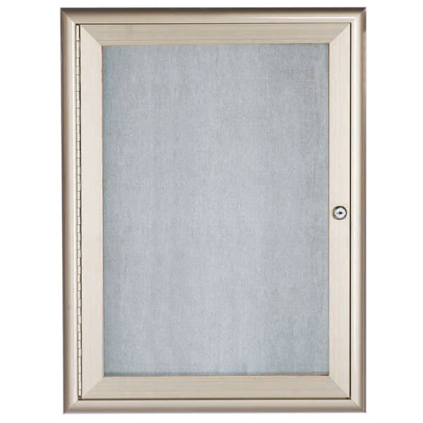 A silver framed door with a glass panel enclosing a grey felt board.