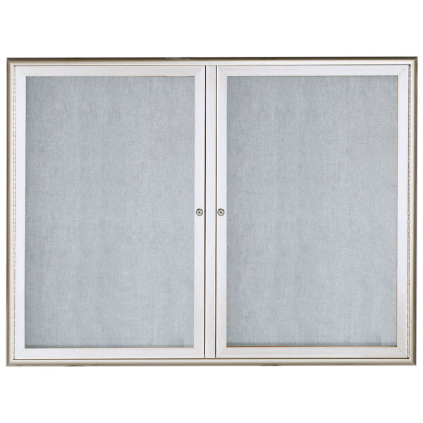 An Aarco silver enclosed bulletin board with glass doors.