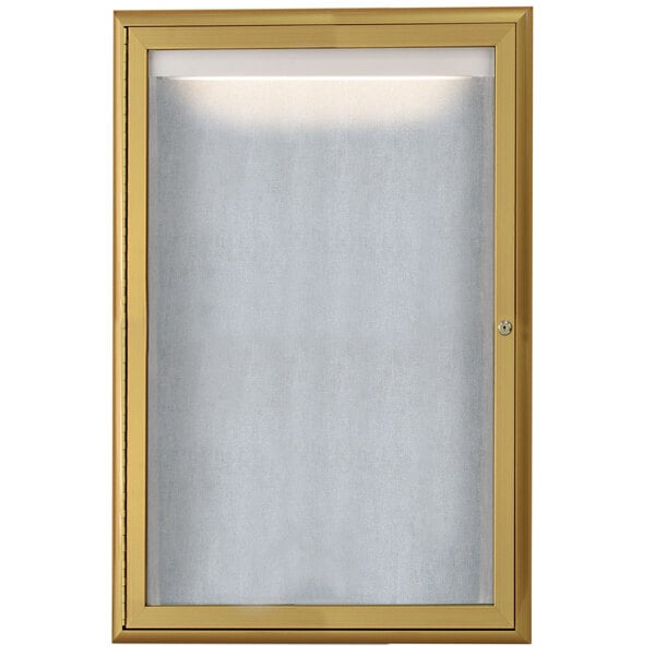 An Aarco gold framed cabinet with a white board inside and LED lighting.