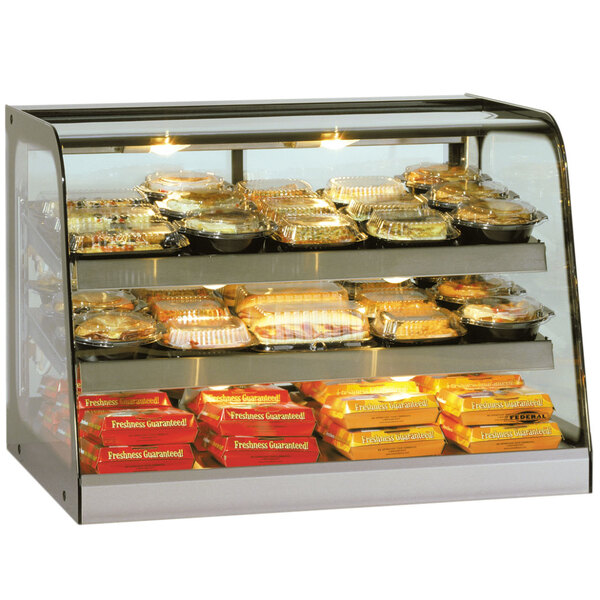 A Federal Industries CH2428 Heated Countertop Display Cabinet filled with food on a bakery counter.