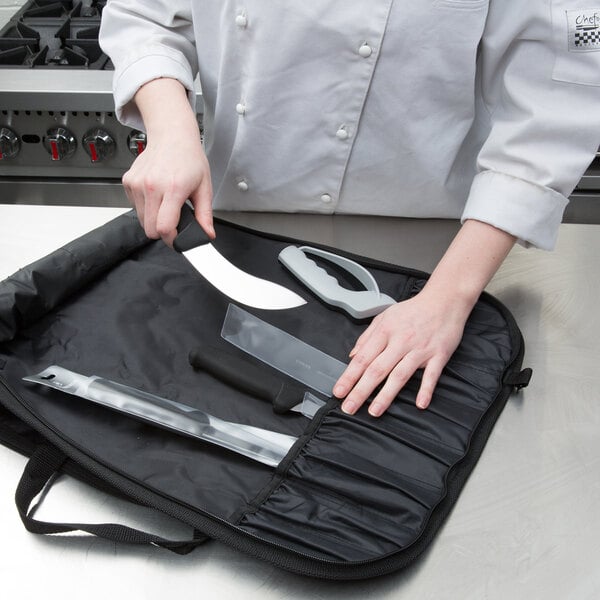 A chef holding a Victorinox knife in a black carrying case.