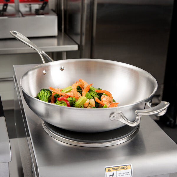 A Vollrath stainless steel stir fry pan with vegetables and shrimp in it.