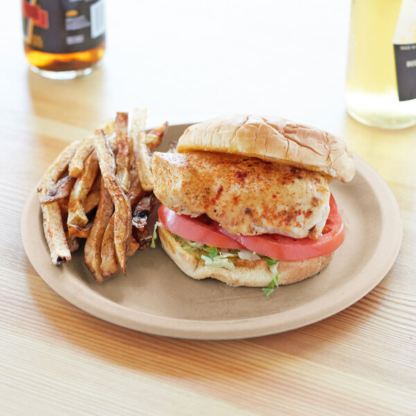 A Eco-Products wheat straw plate with a chicken sandwich, fries, and tomato and lettuce on it.