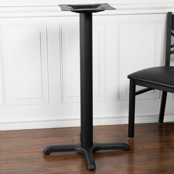 A black table base with a black pole and a black table on it.