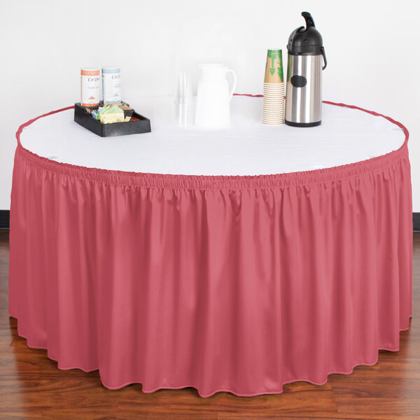 A table with a Snap Drape dusty rose shirred pleat table skirt on it.