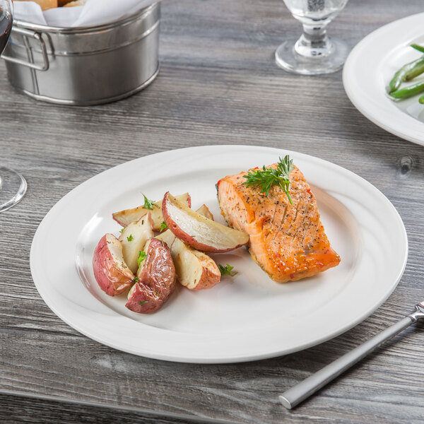 A Libbey Royal Rideau porcelain plate with salmon and potatoes on it.