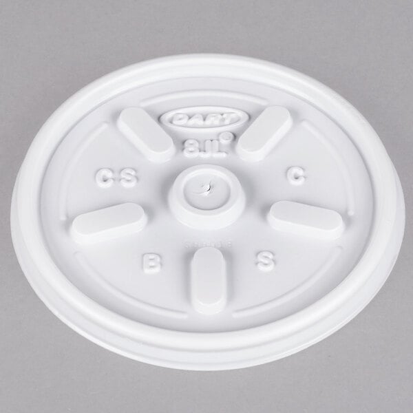 A white plastic lid with four holes and black edges.