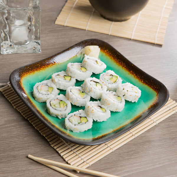 A Libbey stoneware plate with sushi on a table.