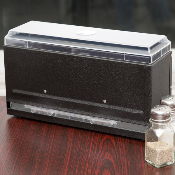 A black plastic box with clear lid and a couple of salt shakers inside a Vollrath Straw Boss dispenser.