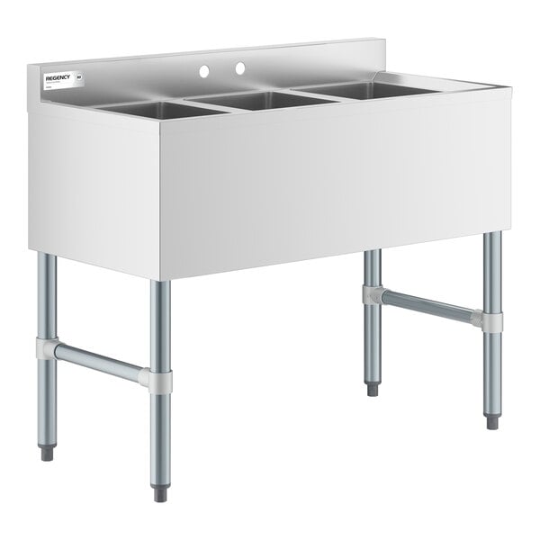 A stainless steel sink unit with three separate square basins and four metal legs.