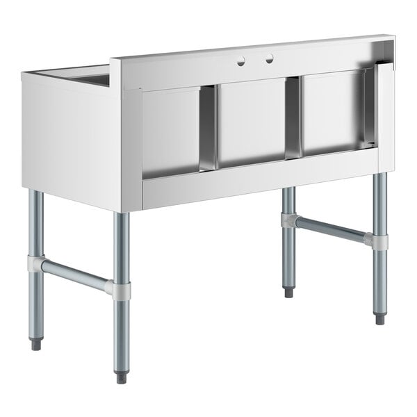 A stainless steel three-compartment underbar sink with four metal legs and a raised backsplash.