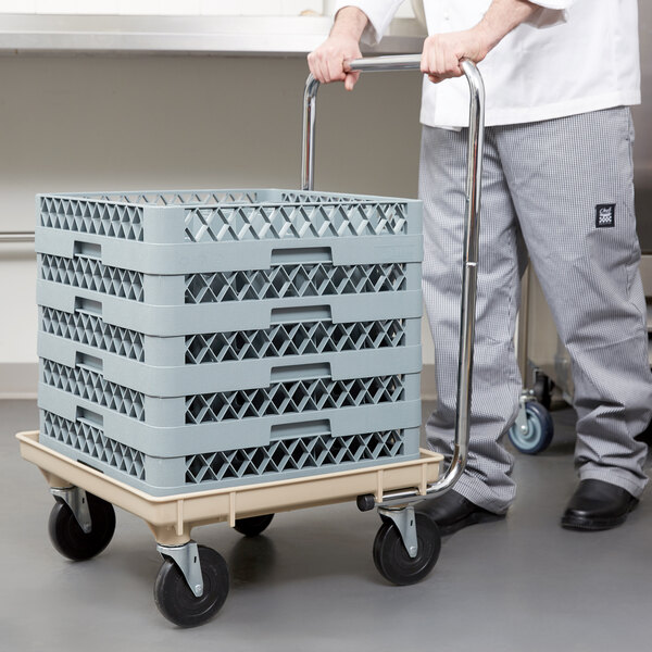 A man pushing a Vollrath Traex rack dolly with a stack of crates.