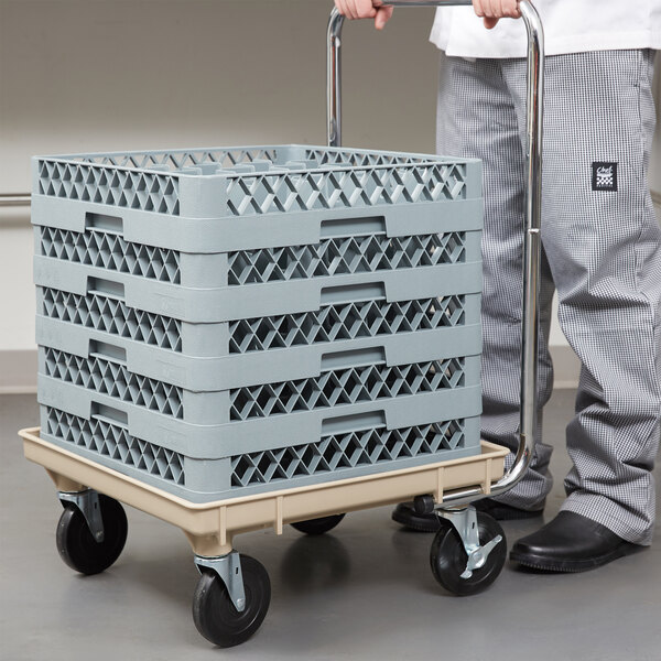 A person pushing a Vollrath rack dolly with a stack of plastic crates.