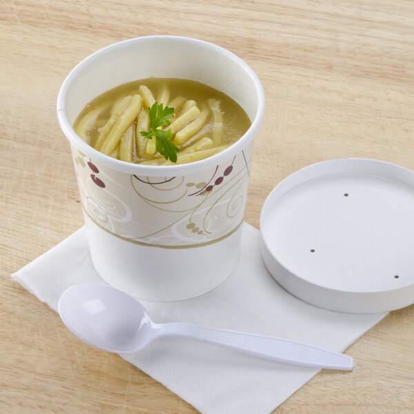 A Solo Symphony paper soup cup with a vented lid filled with soup and a spoon.