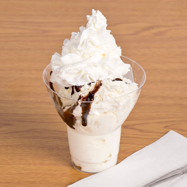 A WNA Comet Classic Crystal parfait cup filled with ice cream and chocolate syrup.