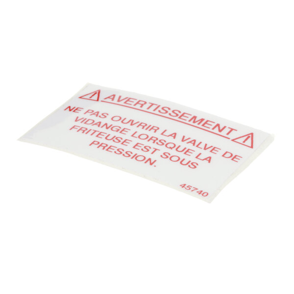 A white Henny Penny label drain valve with red "Attention" text.