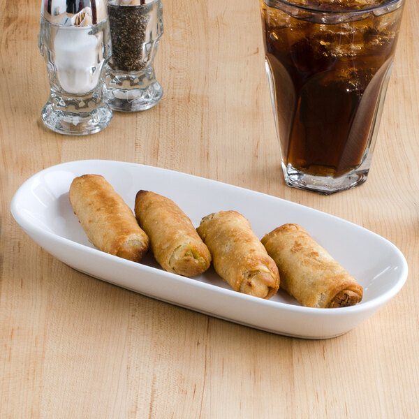 A white Tuxton china relish tray with fried spring rolls and a glass of ice.