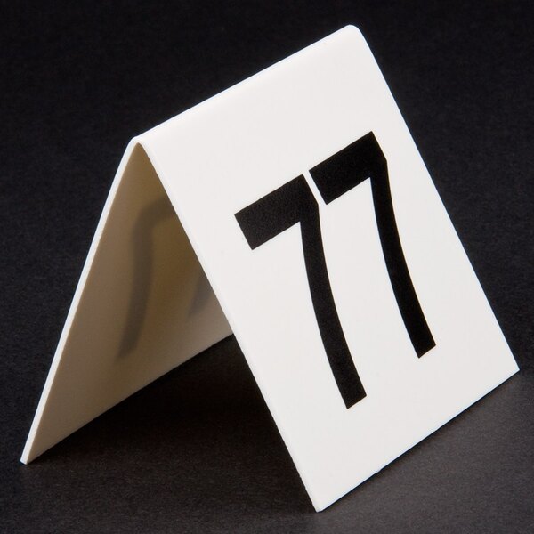 A white table tent card with the number 77 in black.