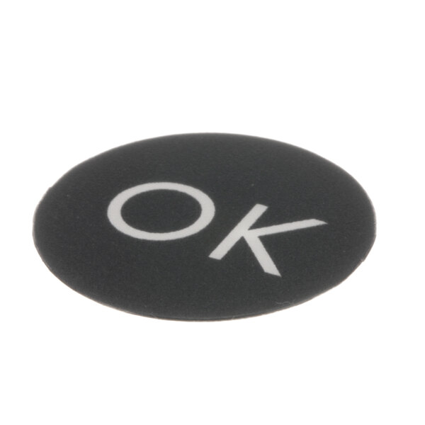 A black circle with white letters that say "Ok" on a white surface.