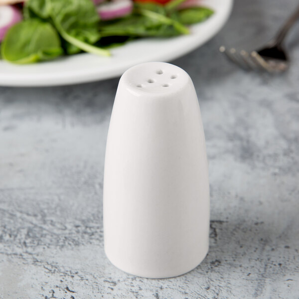 A Libbey ivory porcelain pepper shaker on a table.