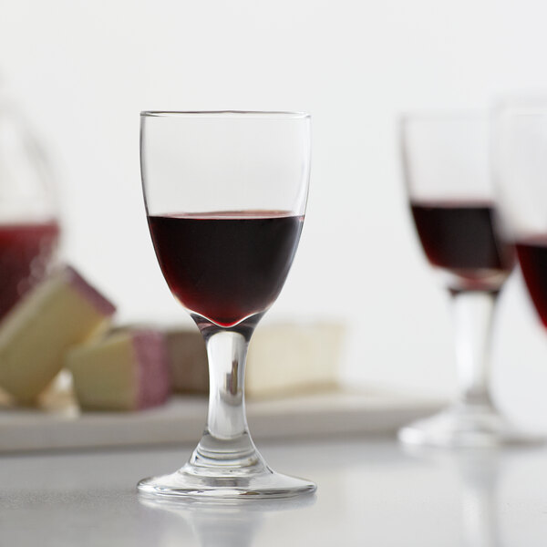 A close up of a Libbey sherry glass filled with red wine.