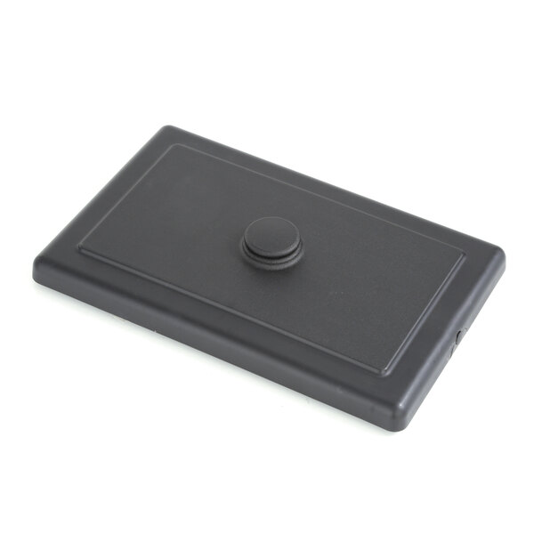 A black rectangular plastic Taylor cover with a button.