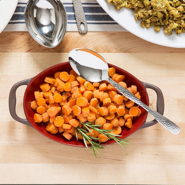 A bowl of carrots with a spoon in it.