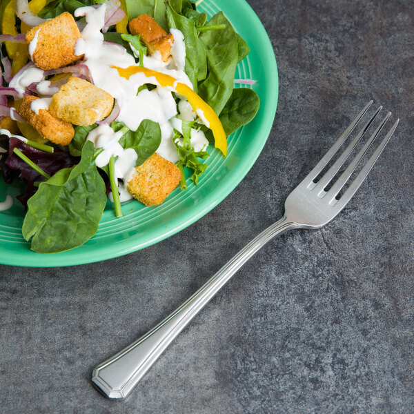 A green salad in a green plate with a Bon Chef stainless steel dinner fork.