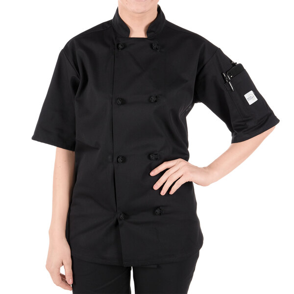 A woman wearing a black Mercer Culinary chef coat with knot buttons.