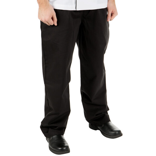 A man wearing Mercer Culinary black chef pants and a white shirt.
