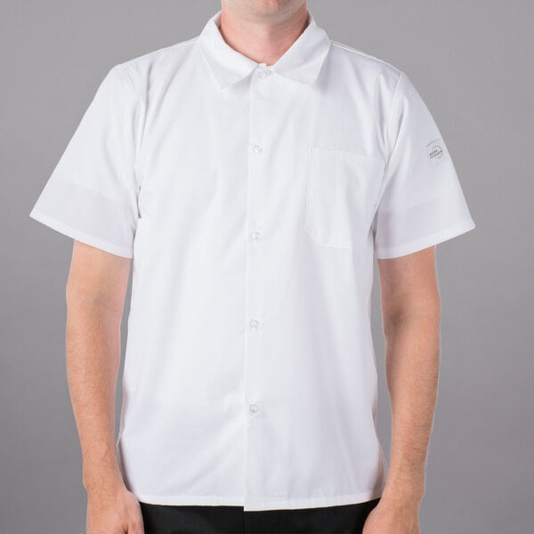 A man wearing a Mercer Culinary Millennia white cook shirt with full mesh back.