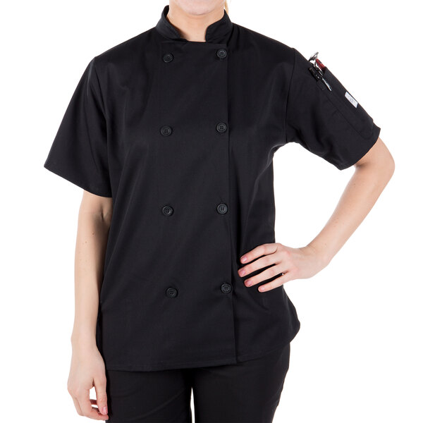 A woman wearing a black Mercer Culinary chef jacket with short sleeves.