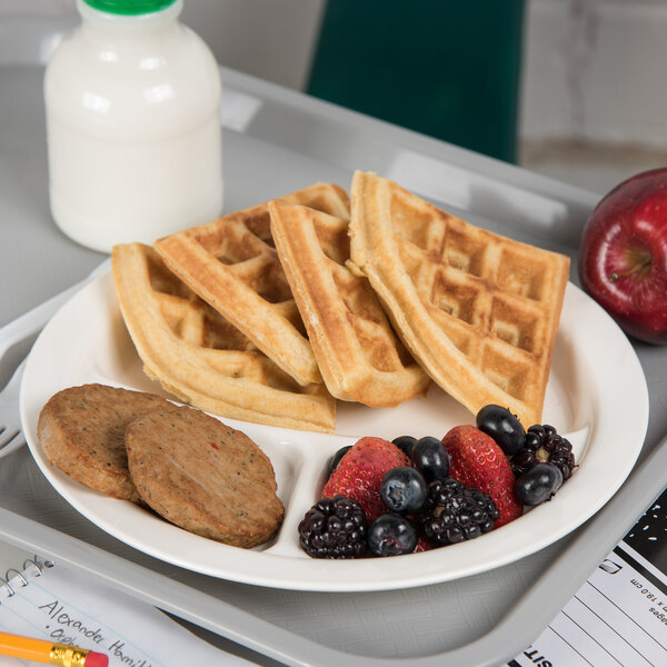 A Carlisle polycarbonate plate with waffles and fruit on a tray.
