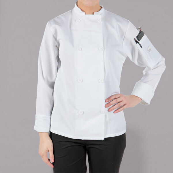 A woman wearing a white Mercer Culinary chef jacket with long sleeves.