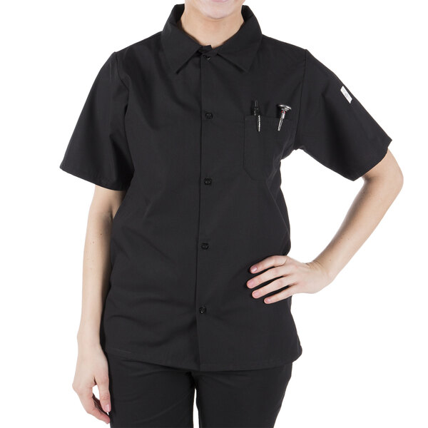 A woman wearing a black Mercer Culinary cook shirt with a mesh back.