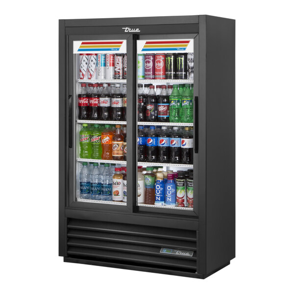 A True 36-inch black narrow convenience store merchandiser refrigerator with sliding glass doors full of drinks.
