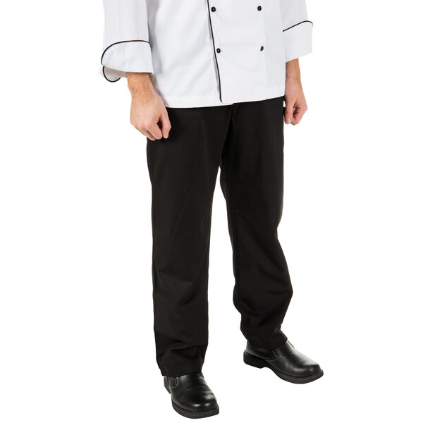 A man wearing Mercer Culinary black chef trousers and a white chef coat.