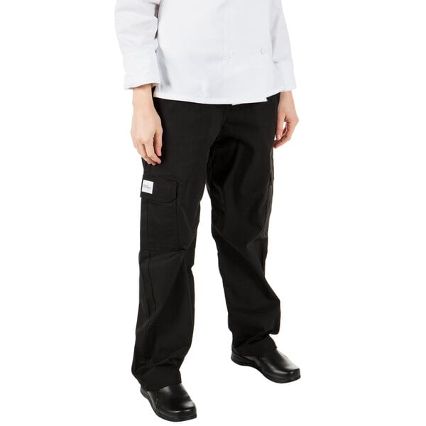 A young woman wearing Mercer Culinary black chef cargo pants.