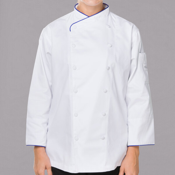 A woman wearing a white Mercer Culinary chef coat with royal blue piping.