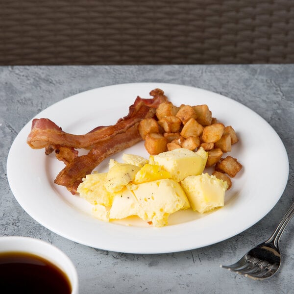 A Reserve by Libbey bone china plate with bacon, eggs and hash browns on a table with a cup of coffee.
