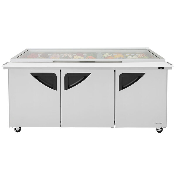 A Turbo Air refrigerated sandwich prep table with glass lids over three doors.