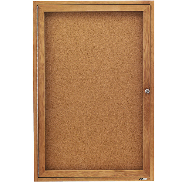 A Quartet enclosed cork board with a wooden frame.