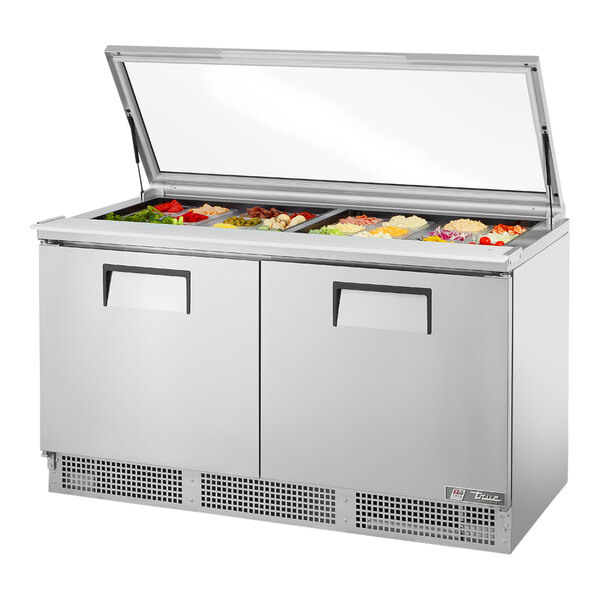 A True refrigerated sandwich prep table with a hinged glass lid over food trays.